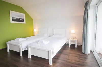 a bedroom with two beds and a green wall at The Saddlers House - best price per bed in Bowmore