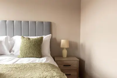 a bedroom with a bed and a lamp on a night stand at Airth House in Airth