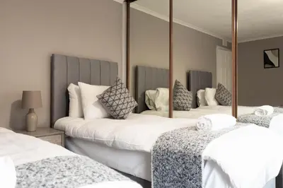 a bedroom with two beds and a large mirror at Airth House in Airth
