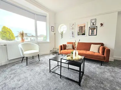 a living room with a couch and a chair at Charming 3-Bed Oasis-free parking in Glasgow