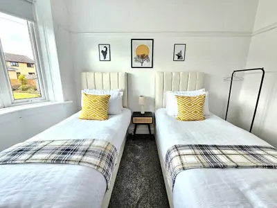 two beds sitting next to each other in a room at Charming 3-Bed Oasis-free parking in Glasgow