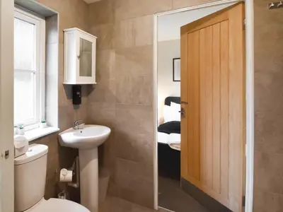 a bathroom with a toilet and a sink and a door at Ptarmigan Lodge in Balmaha