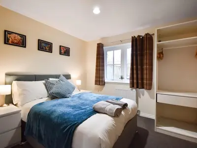 a bedroom with a bed and a window at Ptarmigan Lodge in Balmaha