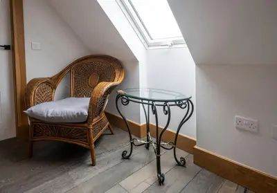 a wicker chair and a glass table in a room at Avoca Lodge in Fort William