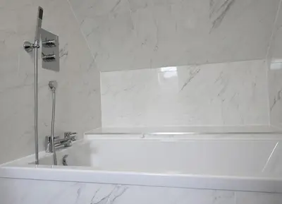 a white bath tub in a bathroom with marble walls at Avoca Lodge in Fort William