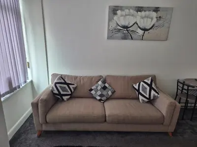 a living room with a couch with pillows on it at M Rooms 97a at the Brandy Bar in Kirk of Shotts