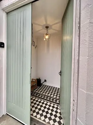 a hallway with a door and a checkered floor at 1 The Cairn Kilmartin - Beautiful Victorian Flat, Pet Friendly in Kilmartin