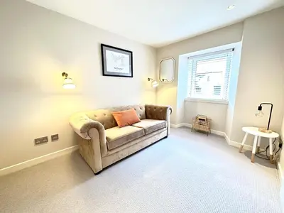 a living room with a couch and a window at 1 The Cairn Kilmartin - Beautiful Victorian Flat, Pet Friendly in Kilmartin