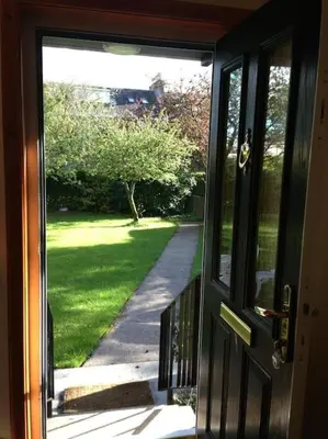 an open door with a view of a yard at Garden Cottage Helensburgh in Helensburgh