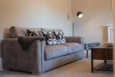 a couch with pillows on it in a living room at South Beach View in Troon