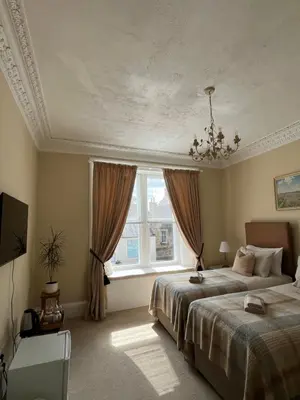 a bedroom with two beds and a window at Acorn House Callander in Callander