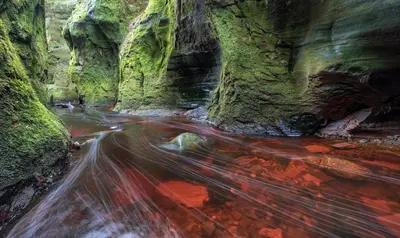 a long exposure photo of a stream in a canyon at The Mar Huts - The Lomond Hut in Drymen
