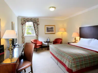 a hotel room with a bed and a desk and chairs at Macdonald Houstoun House in Livingston