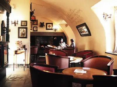 a restaurant with tables and chairs and a fireplace at Macdonald Houstoun House in Livingston