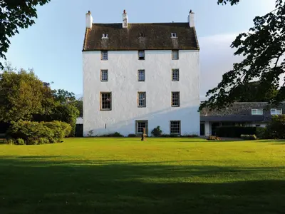 a large white building on a grass field at Macdonald Houstoun House in Livingston