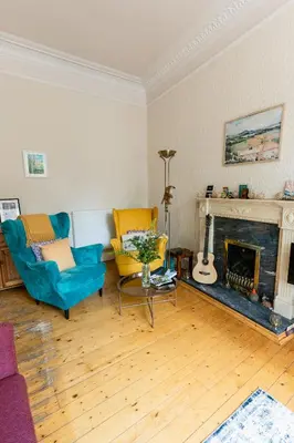 a living room with two chairs and a fireplace at Palm Tree Apartment- Period Home with Cat in Edinburgh