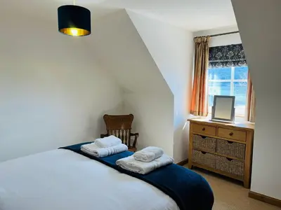 a bedroom with a bed with two towels on it at Avoca House in Fort William