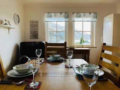 a dining room table with plates and glasses on it at Avoca House in Fort William