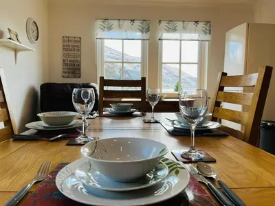 a table with a bowl and plates and glasses on it at Avoca House in Fort William