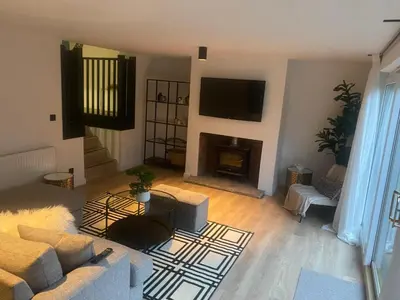 a living room with a couch and a fireplace at Sleeps7-Parking-Garden-Patio in Johnstone