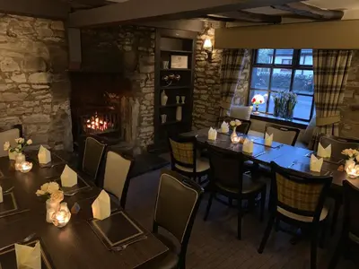a restaurant with tables and chairs and a fireplace at Lion and Unicorn Hotel in Thornhill