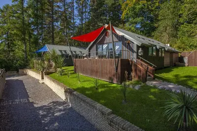 a small house with a red roof in a yard at Dundonald Landing Palms 2 in Oban