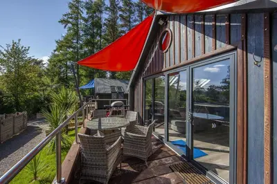 a house with a patio with a table and chairs at Dundonald Landing Palms 2 in Oban