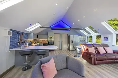 a living room with a couch and a kitchen at Dundonald Landing Palms 2 in Oban