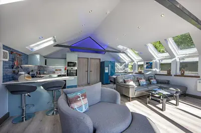 a kitchen and living room with blue walls and windows at Dundonald Landing Palms 1 in Oban