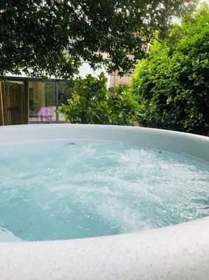 a hot tub with blue water in a yard at Keppochhill - Beautiful Home with Hot Tub in Banton