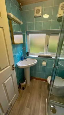 a small bathroom with a sink and a toilet at 1 Bedroom Cabin with Mountain & Loch Views - Quiet Location between Glencoe & Ben Nevis in Corran