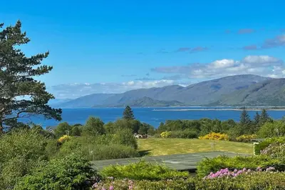 a view of a lake with mountains in the background at 1 Bedroom Cabin with Mountain & Loch Views - Quiet Location between Glencoe & Ben Nevis in Corran