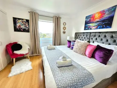 a bedroom with a large bed and a chair at 3 Bed House with 6 Beds by Sensational Stay in Edinburgh