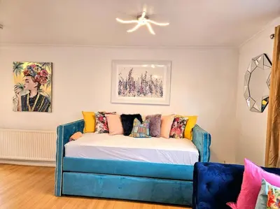 a bed in a room with a blue couch at 3 Bed House with 6 Beds by Sensational Stay in Edinburgh