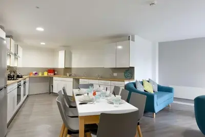 a kitchen with a dining table and a blue couch at Student Only Ensuite Room in Central Glasgow in Glasgow