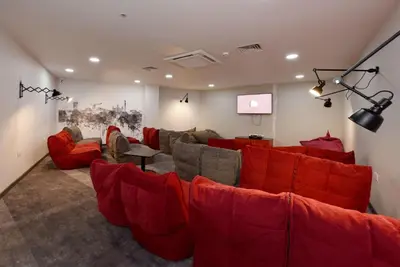 a living room with red couches and a screen at Student Only Ensuite Room in Central Glasgow in Glasgow