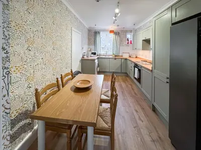 a small kitchen with a wooden table and chairs at Bay View in Oban
