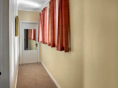 a hallway with red curtains and a door at Bay View in Oban