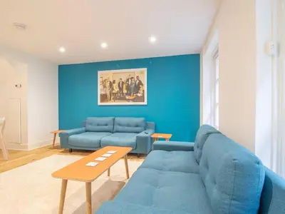 a living room with a blue couch and a table at Stylish West End Detached Mews - Pass the Keys in Glasgow