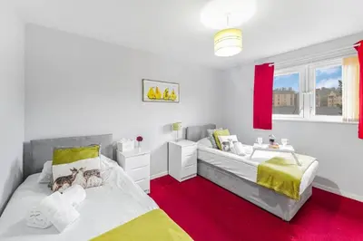 a bedroom with two beds and a red carpet at PREMIER - Maryhill Apartment in Glasgow