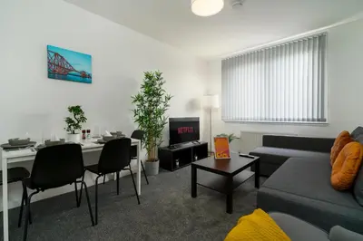 a living room with a couch and a table at Free Parking - 2 Bedroom Flat-by Holiday Homes in Cambusnethan