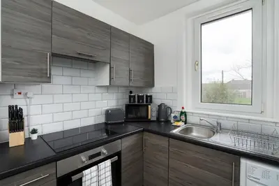 a kitchen with a sink and a window at Free Parking - 2 Bedroom Flat-by Holiday Homes in Cambusnethan