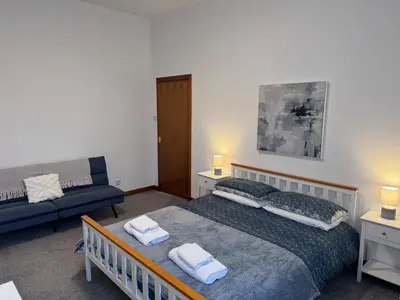 a bedroom with a bed and a couch at Ben Lomond Apartment - Macaulay Letting in Alexandria