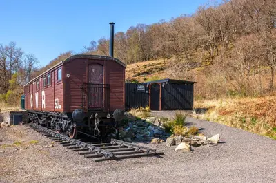 an old train car sitting on the tracks at Appin Holiday Homes -Caravans, Lodges, Shepherds Hut and Train Carriage stays in Appin