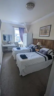 a hotel room with three beds in a room at Dalgair House Hotel in Callander