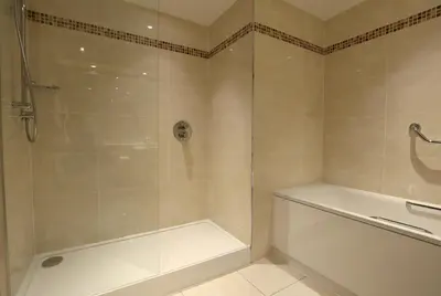 a bathroom with a shower and a white tub at Macdonald Forest Hills Hotel & Spa in Aberfoyle