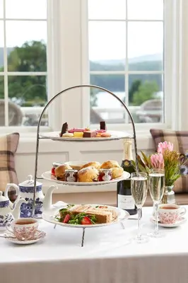 a table with two plates of food and glasses of wine at Macdonald Forest Hills Hotel & Spa in Aberfoyle