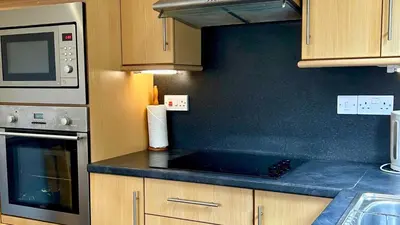 a kitchen with a stove and a microwave at Jura in Oban