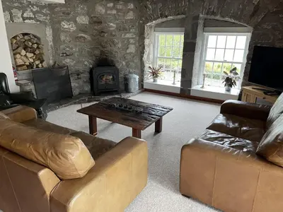 a living room with a couch and a coffee table at Craigruie Farmhouse in Balquhidder