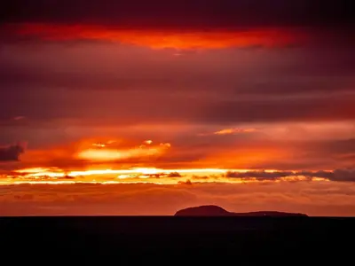 a sunset over the ocean with a mountain in the distance at Barnstable - Uk46888 in Kilmory